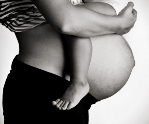 pregnant woman holding child chest down 6